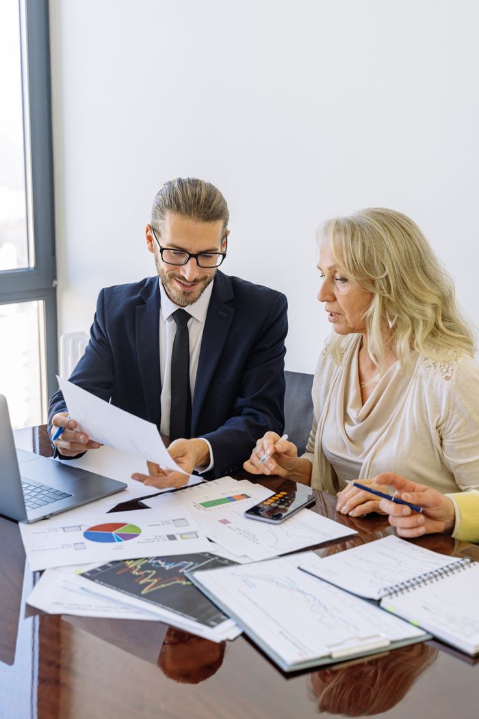 Crafting Captivating Headlines: Your awesome post title goes here Two business professionals reviewing financial documents and graphs during a meeting.