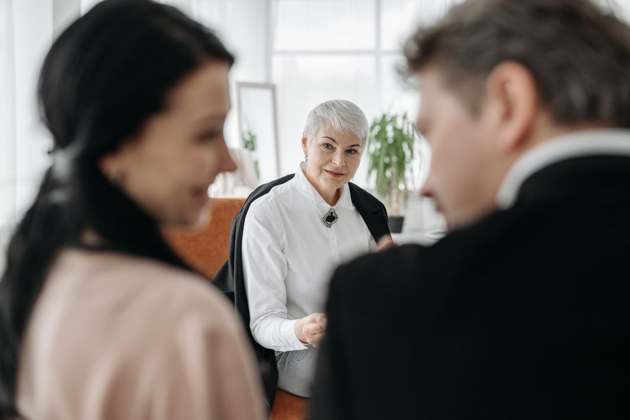 A professional consultation session with a couple and a social worker in a modern office environment.
